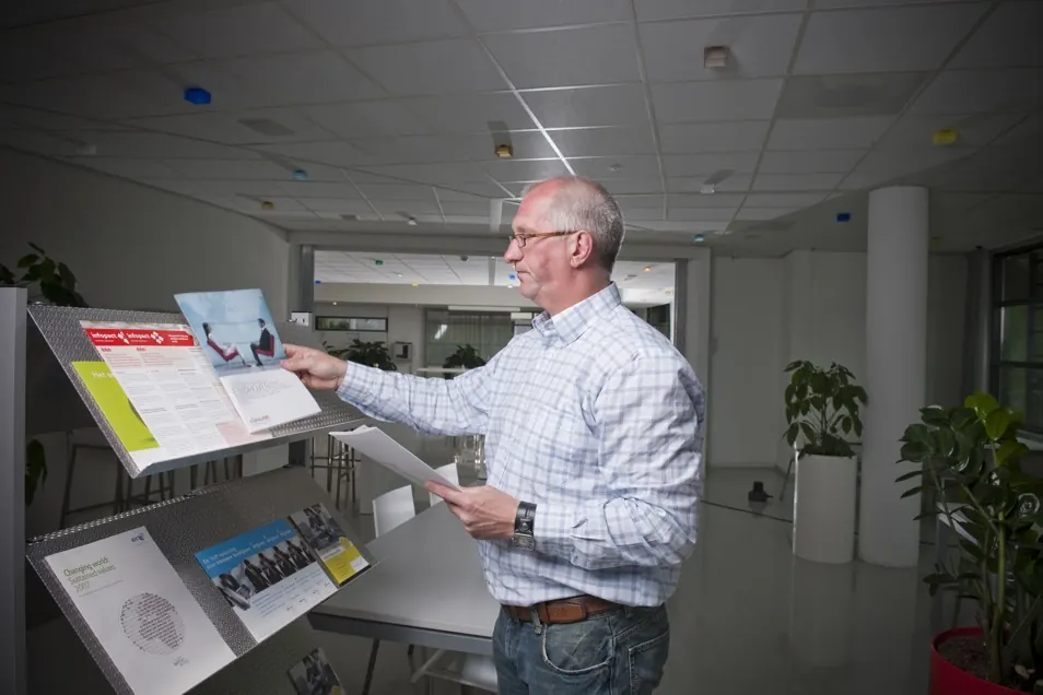 Gebouwbeheerder bekijkt informatieborden in een kantoorpand